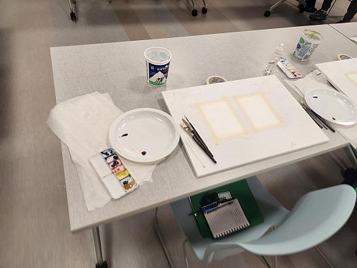 View of a table with paint materials set up.